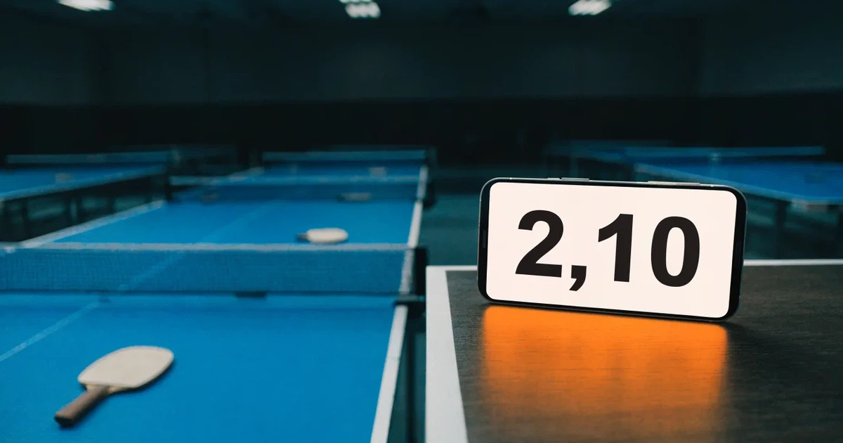 Eine Tischtennishalle aus erhöhter Perspektive mit mehreren blauen Tischen in Reihen unter gedämpftem Hallenlicht, ohne Personen.